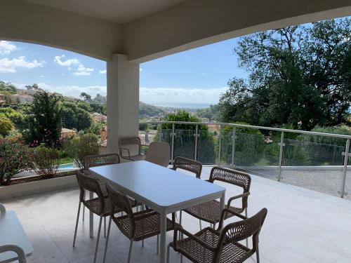 - une table et des chaises blanches sur la terrasse avec vue dans l'établissement Superbe appartement 4 Pièces - Accès Piscine, à Cagnes-sur-Mer