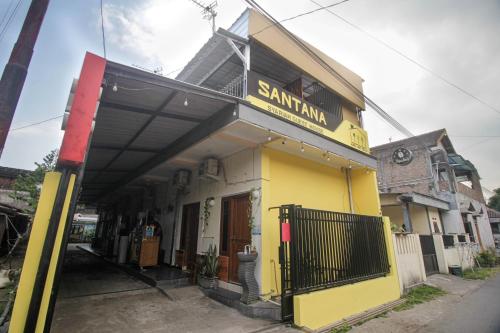 a yellow building with a santiam sign on it at Capital O 2258 Santana Syariah Guest House in Solo