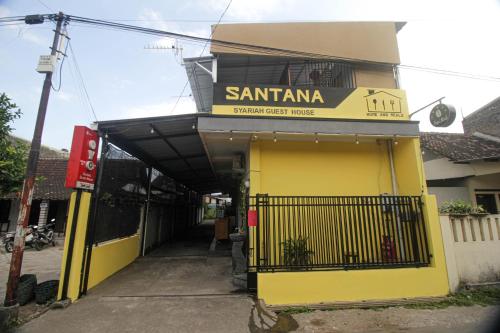 a yellow building with a sign that reads santana supermarket house at Capital O 2258 Santana Syariah Guest House in Solo
