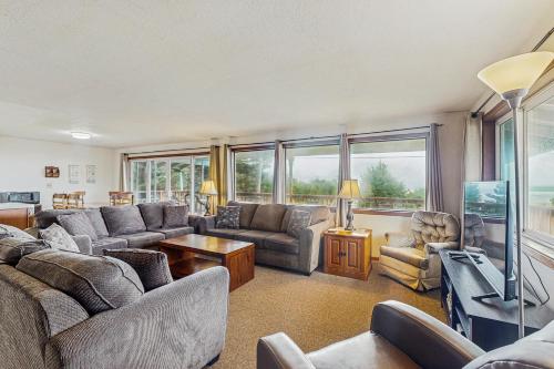 a living room with couches and a flat screen tv at Falcon's Nest in Twin Rocks