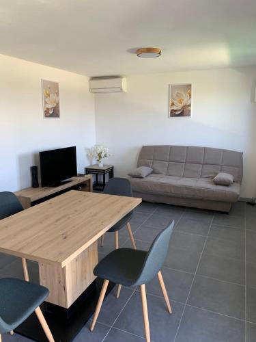 un salon avec une table en bois et un canapé dans l'établissement Maisonnette de Michelle - Peace and quiet, à La Gaude