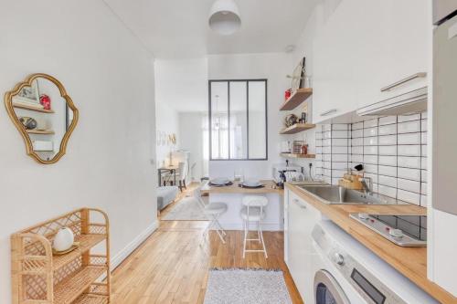 Il comprend une cuisine avec des murs blancs, du parquet et un évier. dans l'établissement Jerickais - Cozy Studio - Sartrouville - 7 min RER, à Sartrouville