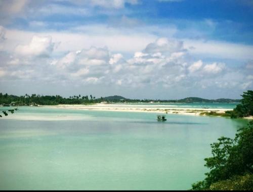 a body of water with a boat in it at casa de 4 quartos perto do Forte Orange Itamaracá in Itamaracá