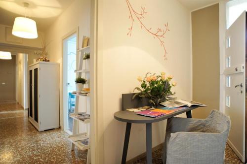 Una habitación con una mesa con flores. en Stop & Sleep Udine, en Udine