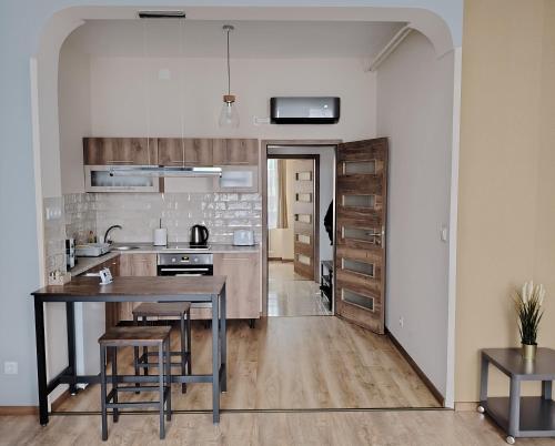 a kitchen with a table and chairs in a room at Sziget Apartman in Tata