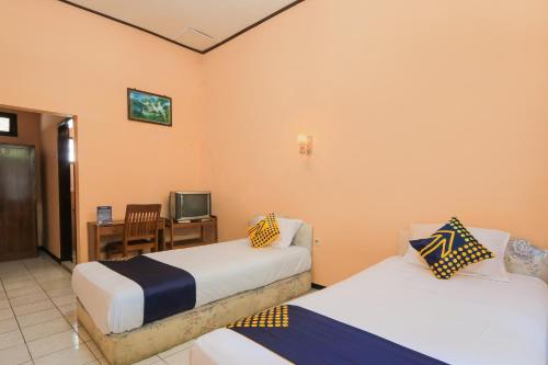 Кровать или кровати в номере OYO 2465 Hotel Raung View