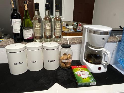 a counter with bottles of wine and a blender at The Coffee Residences at KINGS MILLENNIUM APARTMENTS, near JKI Airport 3 Bedroom in Nairobi