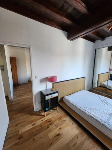 une chambre avec un lit et une table avec une lampe dans l'établissement Charmant T2 à proximité du métro Valmy, à Lyon