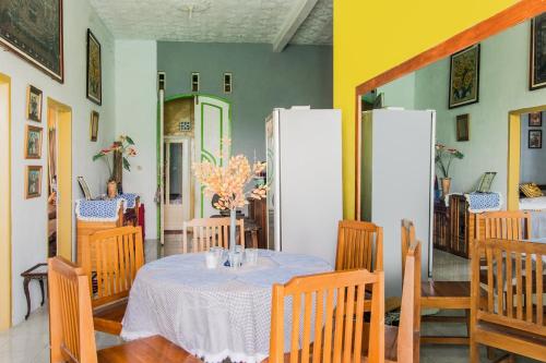 a dining room with a table and a refrigerator at Hotel O Villa Tirta Melati Syariah in Banjar