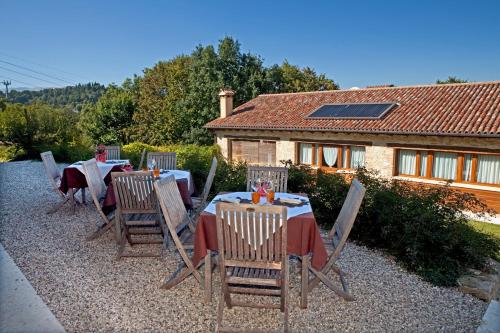 a patio with a table and chairs and a house at Azienda Agrituristica Calronche in Refrontolo