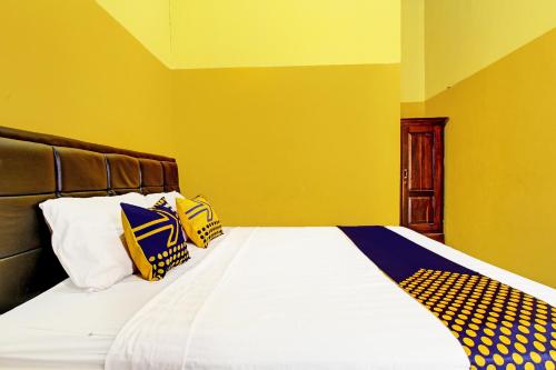 a bedroom with a bed with yellow walls at OYO Life 2546 Griya Widya Syariah in Klaten