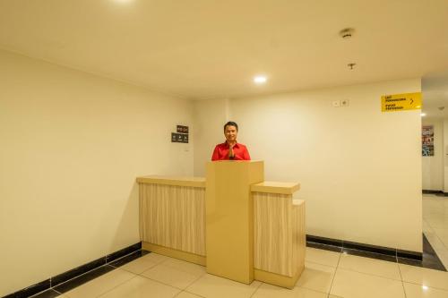 Eine Frau, die hinter einem Podium in einem Raum steht. in der Unterkunft Collection O Hotel Pasar Baru Heritage in Bandung