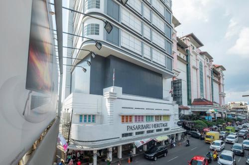 a building on a busy city street with cars at Collection O Hotel Pasar Baru Heritage in Bandung
