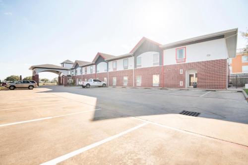 a parking lot in front of a brick building at OYO Townhouse Clute Lake Jackson in Clute