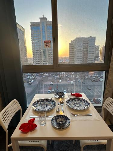 a table with plates on it with a view of a city at Bella INN - Deluxe Master Room - No Smoking in Dubai