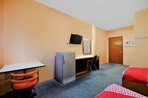 a hotel room with a desk and a refrigerator at OYO 588 Rose In Mansion in Trang