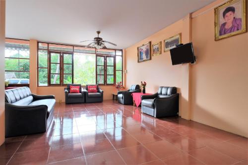 a living room with couches and a flat screen tv at OYO 588 Rose In Mansion in Trang