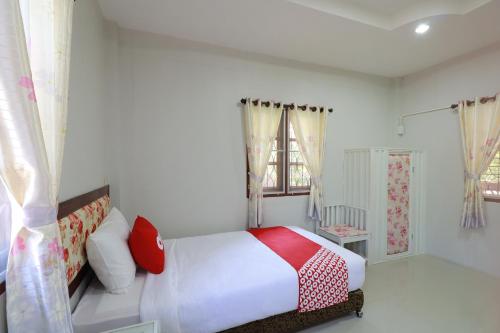 Un pat sau paturi într-o cameră la OYO 553 Kongsup Resort