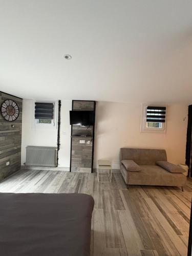 un salon avec un canapé et une horloge au mur dans l'établissement La toulousaine, à Sablons