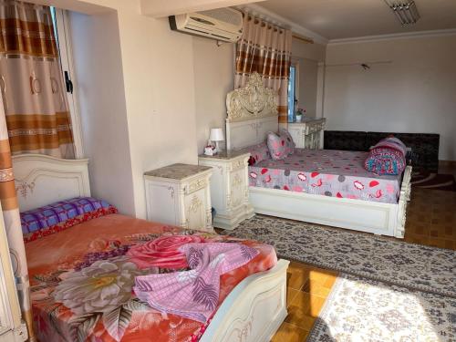 a bedroom with two beds and a mirror at شقة عائليه كبيره مطله علي قناة السويس والبحر 702 in Port Said