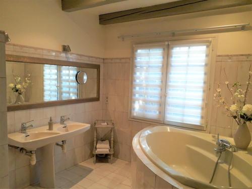 une salle de bain avec une baignoire, un lavabo et une fenêtre dans l'établissement Ocre i Blau, à Canet