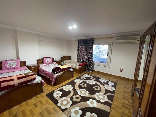 a living room with two beds and a rug at شقة عائليه كبيره مطله علي قناة السويس والبحر 702 in Port Said