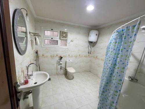 a bathroom with a sink and a toilet and a shower at شقة عائليه كبيره مطله علي قناة السويس والبحر 702 in Port Said
