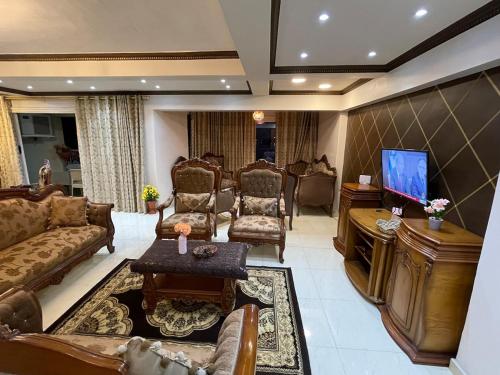 a living room with couches and a flat screen tv at شقة عائليه كبيره مطله علي قناة السويس والبحر 702 in Port Said