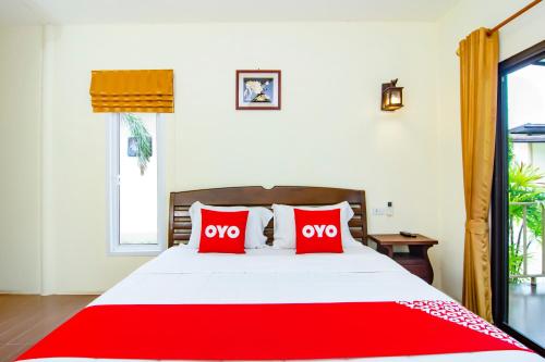 a bedroom with a red bed with two red pillows at OYO 607 Nawang Resort in Hua Hin