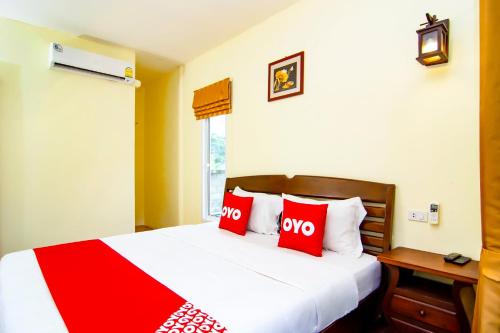 a bedroom with a bed with two red pillows at OYO 607 Nawang Resort in Hua Hin