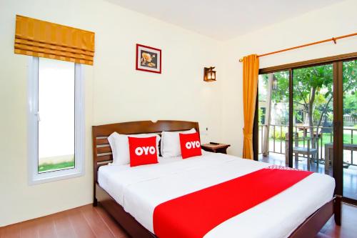 a bedroom with a large bed and a balcony at OYO 607 Nawang Resort in Hua Hin