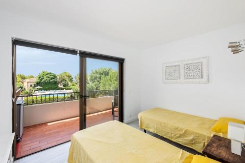 a room with two beds and a balcony with a view at Acogedor apartamento en Betlem in Colonia de Sant Pere