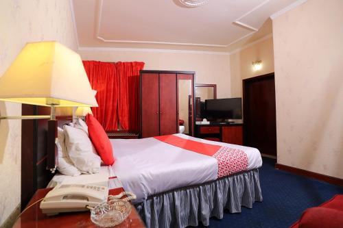 a hotel room with a bed and a telephone at OYO 112 Semiramis Hotel in Manama