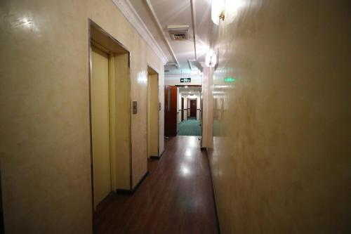 an empty corridor in an office building with a hallway at OYO 112 Semiramis Hotel in Manama