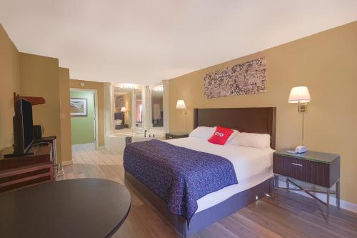 una habitación de hotel con una cama y un televisor en OYO Hotel Brownsville TN I-40, en Brownsville