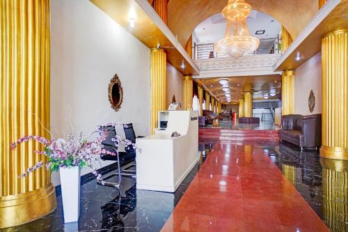 a lobby with yellow columns and flowers in a building at Collection O Medan City Center Near Manhattan Times Square Formerly Grand Z Suites in Medan