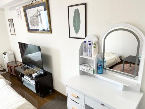 - une chambre avec une coiffeuse blanche et un miroir dans l'établissement 駅南うちやまビル1, à Fukuoka