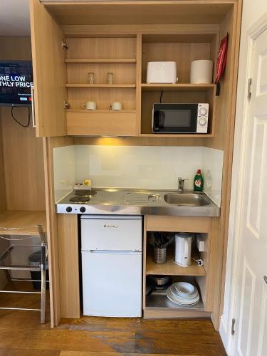 a small kitchen with a sink and a microwave at NOX Kensington in London