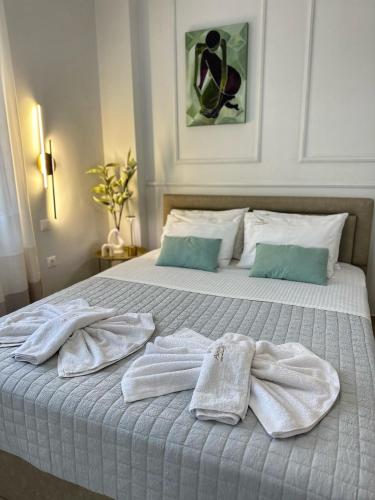 a bed with towels sitting on top of it at Psimithefto Luxury Apartments in Thessaloniki