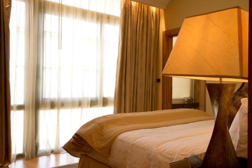 a bedroom with a bed with a lamp next to a window at Phoenicia Residence in Beirut