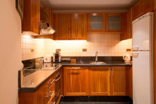 a kitchen with wooden cabinets and a sink at Phoenicia Residence in Beirut
