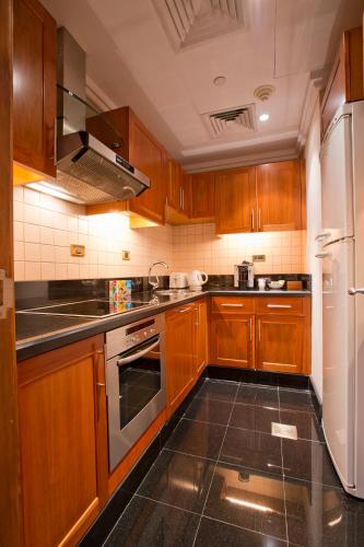 a kitchen with wooden cabinets and stainless steel appliances at Phoenicia Residence in Beirut