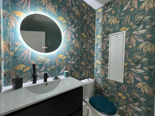 une salle de bain avec un lavabo et un miroir au mur dans l'établissement Un duplex à PARIS DAUMESNIL, à Paris