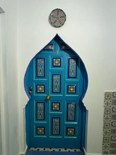 a blue door with a clock on the wall at Casa Blue Star in Chefchaouene