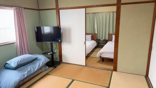 a room with a bedroom with a bed and a tv at 瀬戸内塩上町 in Sambanchō