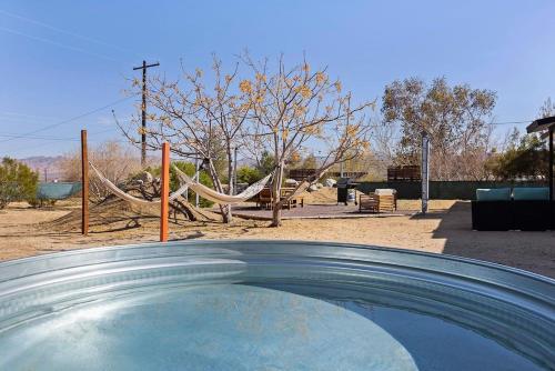Una vista de un parque infantil con una hamaca. en The Labyrinth, en Joshua Tree