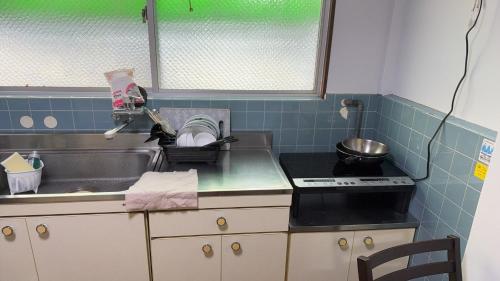 a kitchen counter with a sink and a sink at 瀬戸内塩上町 in Sambanchō