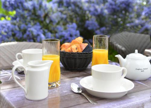 a table with a basket of bread and two glasses of orange juice at La Maison de Mathilde in Bayeux