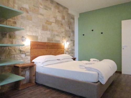 a bedroom with a bed and a stone wall at OASI DA VINCI in Tignale