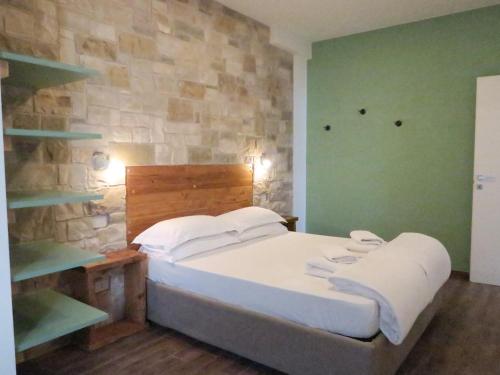 a bedroom with a bed and a stone wall at OASI DA VINCI in Tignale